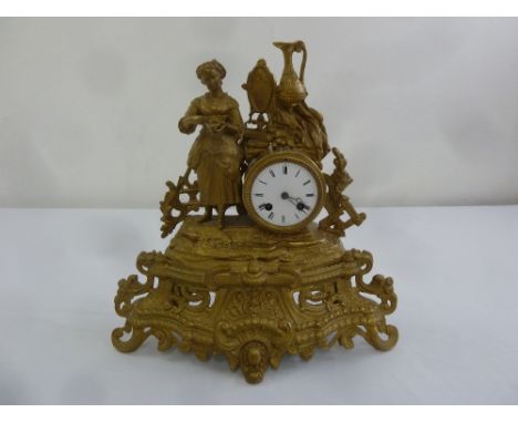 A French style gilded metal mantle clock surmounted by a female figure with white enamel dial and two train movement