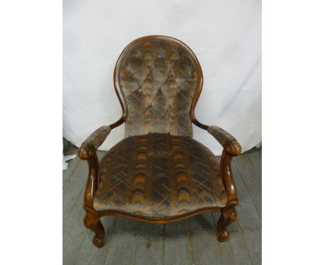 A Victorian mahogany button back upholstered armchair on four scroll legs