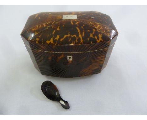 An early 19th century tortoiseshell tea caddy of elongated octagonal form the hinged cover revealing two compartments on four