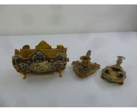 A gilded metal and enamel jardinière on four scroll feet and two chamber sticks