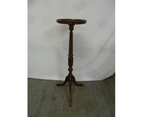 A mahogany pedestal plant stand on tripod base