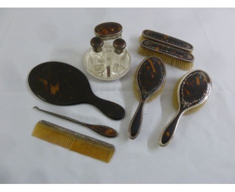 A silver and tortoiseshell dressing table set to include brushes, a button hook and three bottles (11)