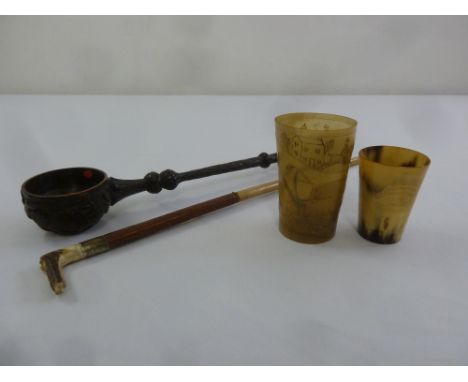 An early 19th century horn beaker the sides carved with hunting scenes, a smaller horn beaker, a carved wooden ladle and a ri