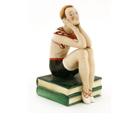 A Goebel figure of a girl,seated on two books, inscribed marks 'XS 104A',15cm high