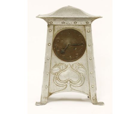 An Art Nouveau aluminium mantel clock,with a shaped top over a tapering embossed and riveted case, mounted with a copper dial