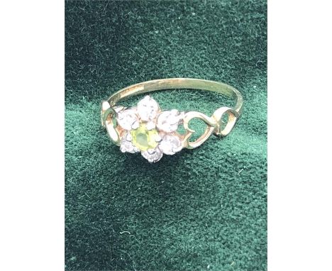 A Peridot and diamond ring in a daisy style and 9ct gold setting