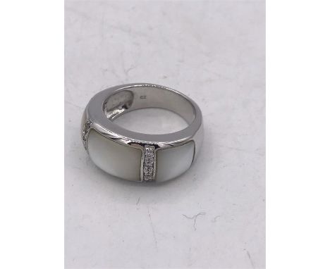 A silver ring set with CZ's and mother of pearl pannels