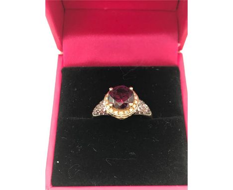 A 14ct Rose Gold ring the central garnet surrounded by diamonds with pink Topaz shoulders