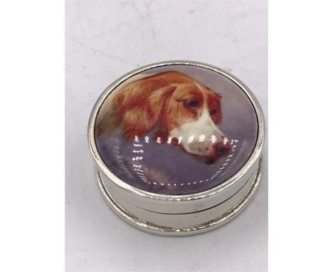 A silver round pill box with enamel plaque depicting a dog