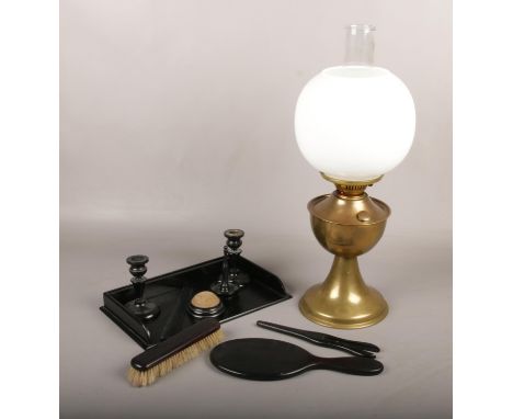 A brass oil lamp with milch glass shade, along with an ebonised dressing table set.  