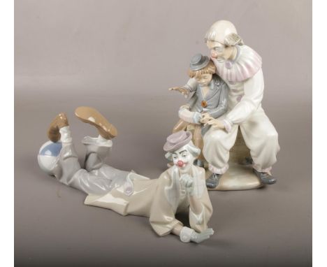 A Lladro figure of a clown laying down, along with a Nao figure group of a clown and a young boy playing a squeeze box.  Both