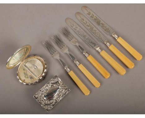 A set of silver collared knives and forks along with a silver cased musical compact and silver matchbox case.  