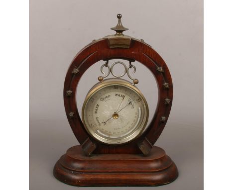 A barometer in cylinder case supported on a horse shoe stand with metal mounts. Maker Curtis of Leicester.  