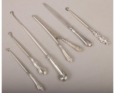 A collection of silver handled items to include button hooks, glove stretchers, letter opener etc.  