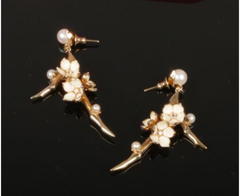 A pair of silver gilt earrings by Shaun Heane. Formed as cherry blossom, with white enamel petals and set with cultured pearl
