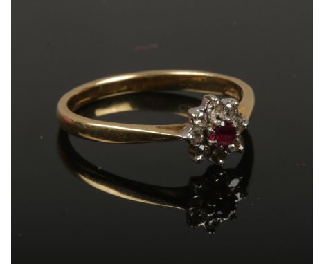 An 18ct gold ruby and diamond daisy cluster ring. Size O, 2.62g.  