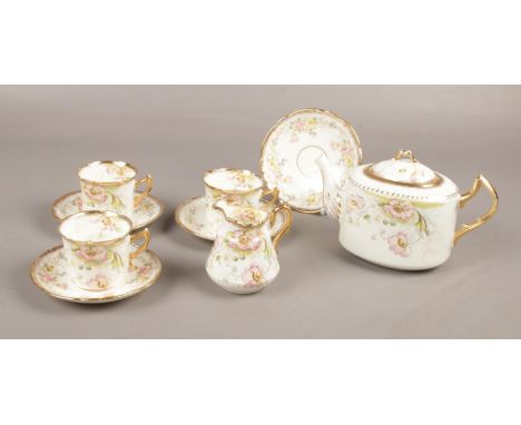 A ceramic floral tea set, teapot, 3 cups, 4 saucers, milk jug.  one cup has cracks down the side