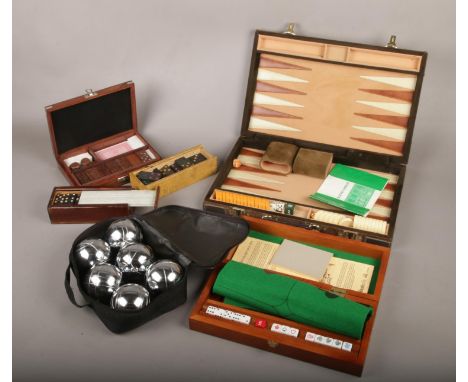 A collection of games, to include The Sailor's Dice Box, dominoes, backgammon and boules.  