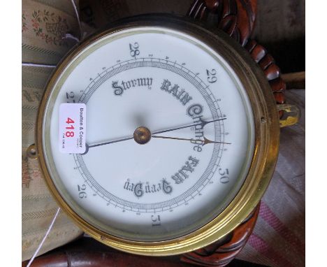 An aneroid Barometer with white dial in a brass bulk head case.  7" (17cms) diameter. 