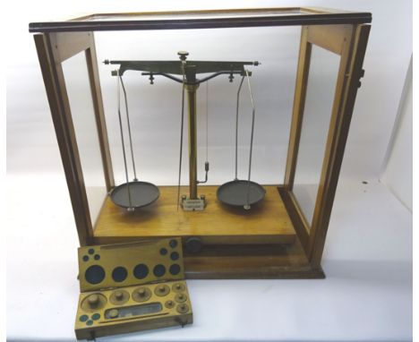 A set of chemical Balance Scales by George & Becker Ltd. in a glaze oak case and complete with a box of weights.
