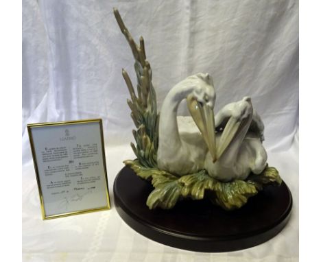 A Lladro limited edition Porcelain Group of two pelicans, mounted on a circular wooden base and with certificate. No.324/1000
