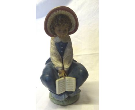 A Lladro matt figure of a seated Child holding a book.  8" (20cms) high.