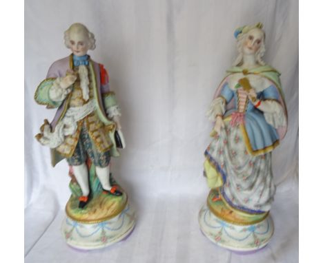 A pair of Continental Bisque china of a Dandy and his Lady on Rococo style circle bases and with impressed L and M mark to ba