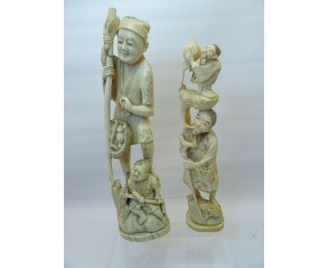 A late 19th Century Japanese carved ivory standing figure of a man with a small figure above, holding a fruiting plant,  9" (