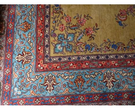 A Central Asian Carpet decorated with a floral medallion centre on a gold field and multi stripe border. 13' (396cms)  x 9' 9