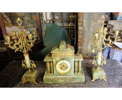 A late Victorian Garniture comprising mantel clock with striking movement in architectural design onyx case and a pair of mat