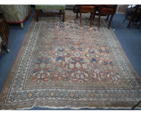 A PINK GROUND PERSIAN RUG, the foliate central panel surrounded by a geometric border, 78" x 116" (worn, insect damage)