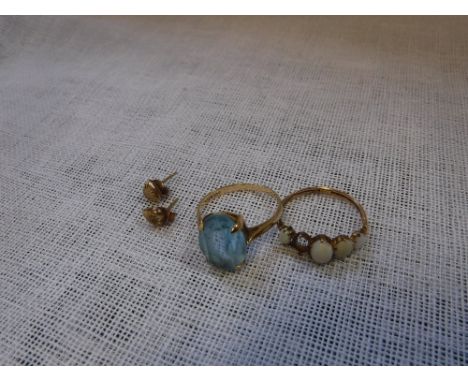 A YELLOW GOLD 9CT PALE BLUE STONE DRESS RING, a pair of yellow metal pierced studs and a yellow metal dress ring set with opa