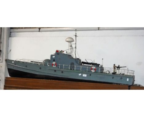 A SCRATCH BUILT OR KIT MODEL OF A BOAT with a mounted machine gun, 60cms