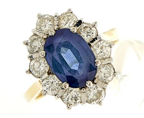 A sapphire and diamond cluster ring, the larger central sapphire approximately 7 x 10mm, in a surround of ten evenly sized di