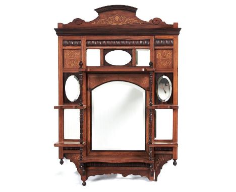 An Edwardian rosewood and inlaid wall mirror, the principal arch topped bevelled plate bordered by seven oval and rectangular