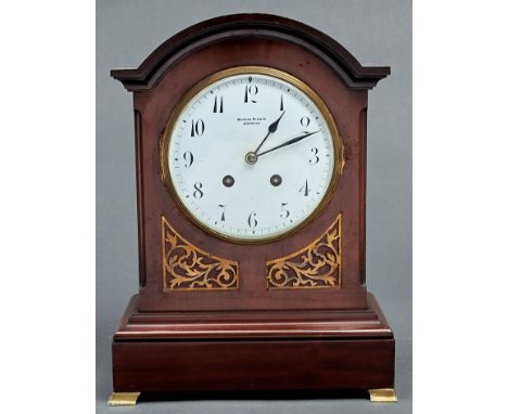 An Edwardian break arched mahogany clock, Winsor Bishop Norwich, with enamel dial, French gong striking movement, brass frets