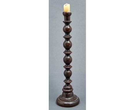 A turned oak candlestick, part 18th c, on domed foot, 51cm h  Minor old losses
