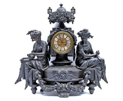 A French fin de siecle bronzed spelter mantel clock, c1900, in the form of a pedestal surmounted by a swagged urn flanked by 