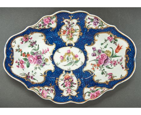 A Worcester scale blue ground dessert dish, c1770, painted in bright enamels with flowers in gilt reserves on a well defined 