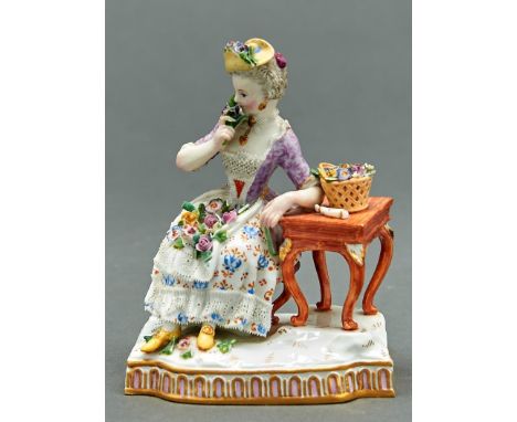 A Meissen figure of smell from a set of the five senses, c1870, after the model by J C Schonheit, as a lady seated beside a t