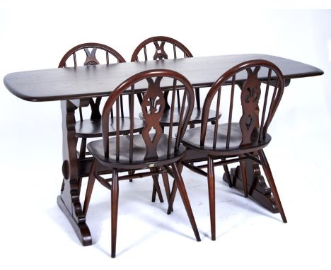 An Ercol elm dining table and set of four chairs, modern, the rounded rectangular top above trestle ends joined by a stretche