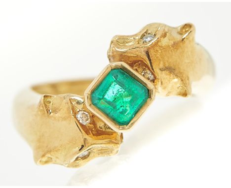 An emerald and diamond 'big cats' ring, the step cut emerald approximately 4.5 x 4.5mm, the cats with diamond eyes, in gold m