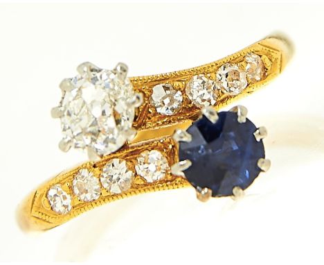 A sapphire and diamond crossover ring, early 20th c, the old cut diamond of approximately 0.25ct, gold hoop with millegrain s