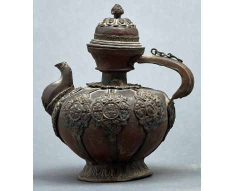 A Tibetan copper teapot and cover, 19th / early 20th c, applied with repousse strapwork and ornament, 24.5cm h  Much old dirt