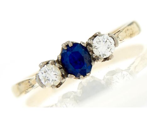 A sapphire and diamond ring, the cushion shaped sapphire flanked by round brilliant cut diamonds, each weighing approximately