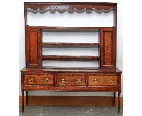 A George III oak dresser, early 19th c, inlaid with shell patera and crossbanded in fruitwood, the rack with spice cupboards,