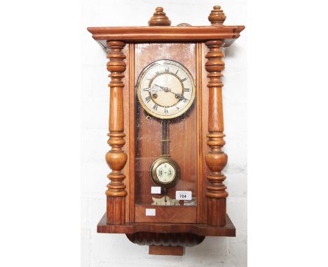 A walnut Vienna wall clock, c1910,&nbsp; with grid iron pendulum, 62cm h  Dial discoloured, case with restorations