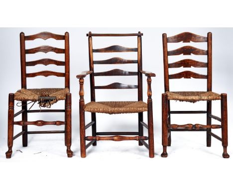 Three elm ladder back chairs, including an elbow chair, all mid 19th c, the elbow chair with yolk style top rail, ladder back