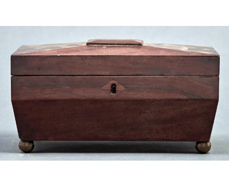 A Regency mahogany sarcophagus shaped tea caddy, the top with central raised rectangular tablet, the hinged lid revealing pai