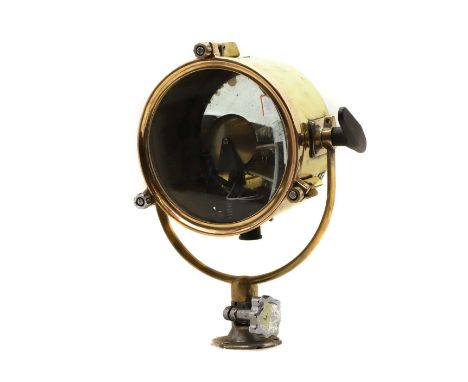 A brass searchlight, a concave mirror back, with an adjusting dial, the light on a rack and pinion mount, on a swivel bracket